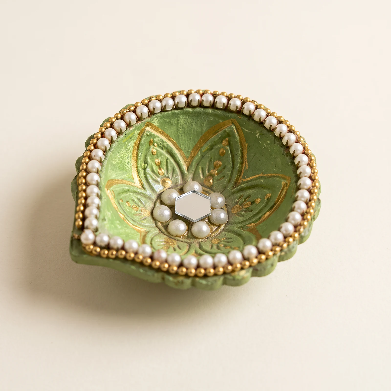 Green Pearl-Border Leaf Diya — handmade details on an ivory background